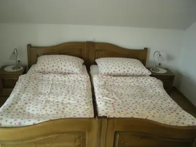 a bed with two pillows on it with two lamps at Turistična Kmetija Logar in Grahovo