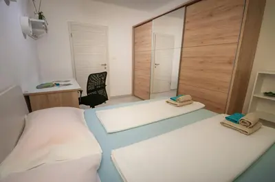 a bedroom with two beds and a desk and a chair at Apartment MATEA in Kobarid