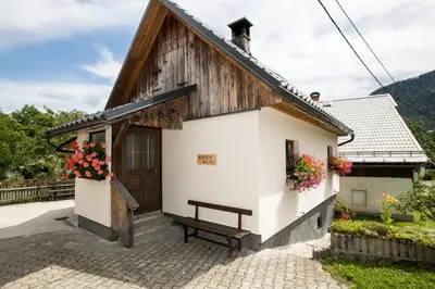 a small house with a bench in front of it at Apartments Kocjanc in Bohinj