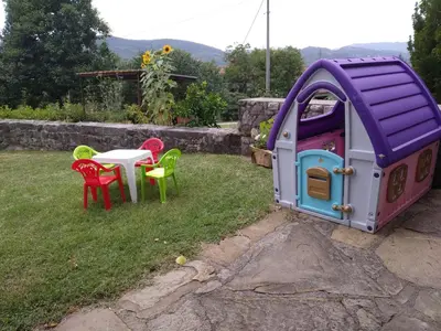 a small house with a table and chairs in a yard at Apartma Kapitanovše in Ajdovščina