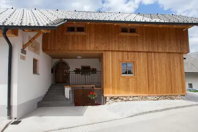 a large wooden building with a porch and stairs at 1861 Blejka apartments Bled in Bled