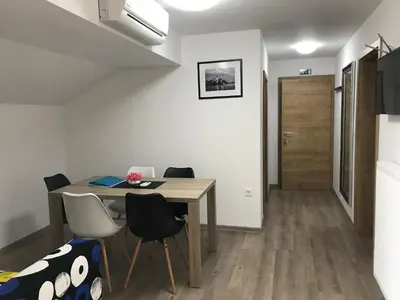 a dining room with a wooden table and chairs at 1861 Blejka apartments Bled in Bled