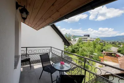 a balcony with a table and chairs and a view at 1861 Blejka apartments Bled in Bled