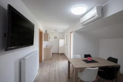 a dining room with a table and a television on a wall at 1861 Blejka apartments Bled in Bled