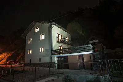 a large white building with its lights on at night at House Utrinek with free play room, jacuzzy and garage in Podbrdo