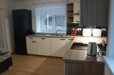 a kitchen with white cabinets and a sink and a window at House Utrinek with free play room, jacuzzy and garage in Podbrdo