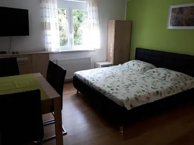 a bedroom with a bed and a table and a desk at House Utrinek with free play room, jacuzzy and garage in Podbrdo