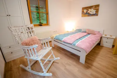 a bedroom with a bed and a rocking chair at Guest House Frata in Dvor
