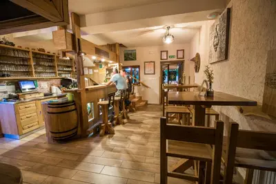 a bar with wooden tables and chairs in a restaurant at Guest House Frata in Dvor