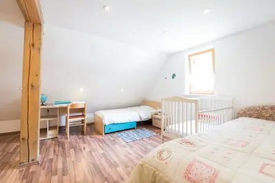 a bedroom with two beds and a desk and a desk at Yellow house in Trenta