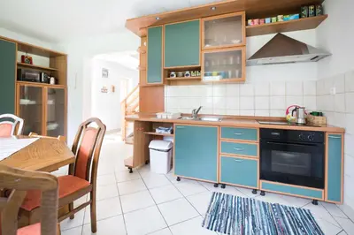a kitchen with blue cabinets and a table at Yellow house in Trenta