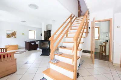 a wooden staircase in a living room with a couch at Yellow house in Trenta