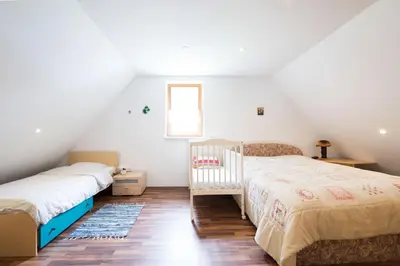 a bedroom with two beds and a crib at Yellow house in Trenta
