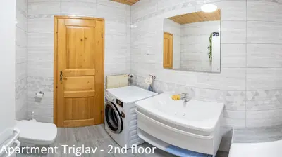 a bathroom with a washing machine and a sink at Apartments Artemida in Bled