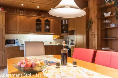a bottle of wine sitting on a table with a bowl of apples at Apartments Artemida in Bled