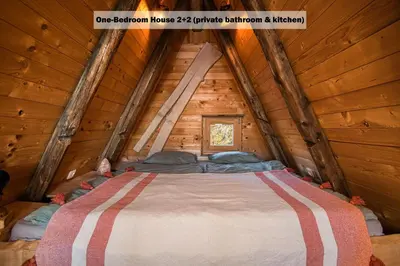 a bedroom in a log cabin with a large bed at Ranch at Geta in Razgorce