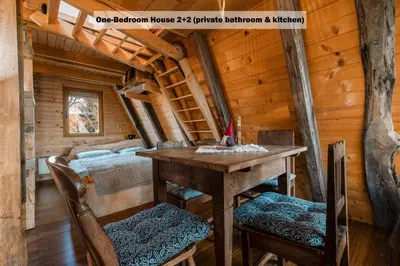 a bedroom in a log cabin with a table and two beds at Ranch at Geta in Razgorce