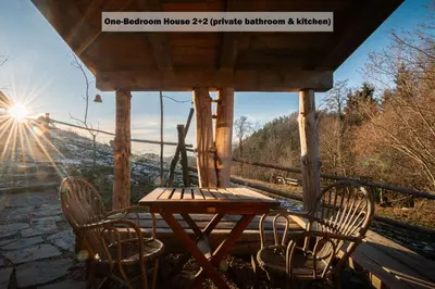 a table and chairs on the porch of a cabin at Ranch at Geta in Razgorce