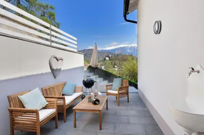 a balcony with chairs and a tub and a table at Apartment Micnek Bled in Bled