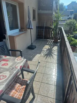 a patio with a table and chairs on a balcony at Apartma Karavanke in Hrušica