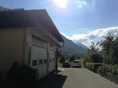a building with two cars parked on a street at Apartma Karavanke in Hrušica