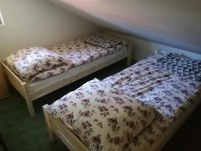 two beds sitting in a room with at Apartma Karavanke in Hrušica