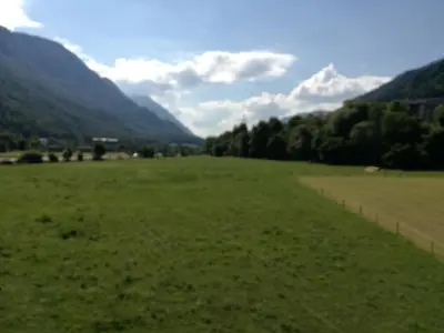 a field of grass with mountains in the background at Apartma Karavanke in Hrušica