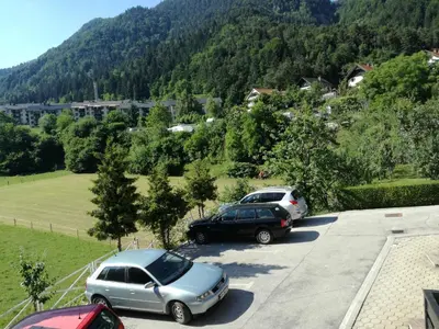 a couple of cars parked in a parking lot at Apartma Karavanke in Hrušica