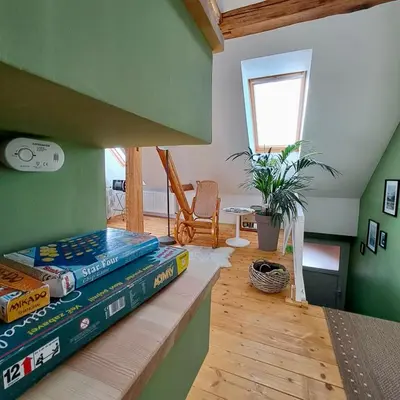 a stack of books sitting on a shelf in a room at Entire Loft close to Beautiful Logar Valley in Rečica ob Savinji
