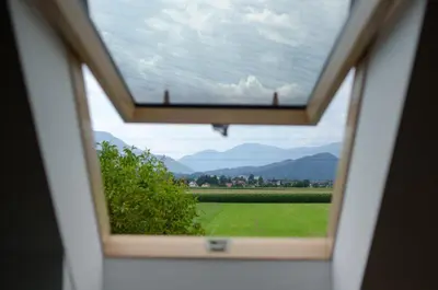 a window with a view of a field and mountains at Entire Loft close to Beautiful Logar Valley in Rečica ob Savinji