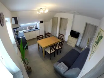 a living room with a blue couch and a table at The Jungle Apartments and Rooms (Vila Džungla) in Bled