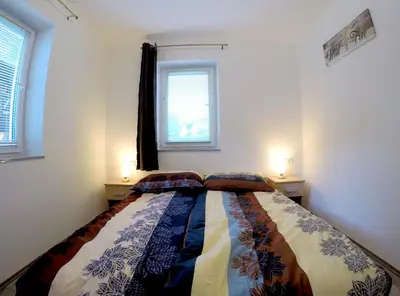 a bedroom with a bed with two lamps on two tables at The Jungle Apartments and Rooms (Vila Džungla) in Bled