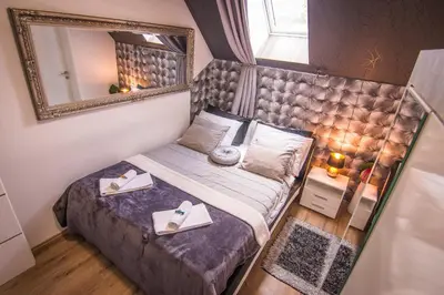 a bedroom with a bed with a large mirror at Vila Lemic Postojna in Postojna