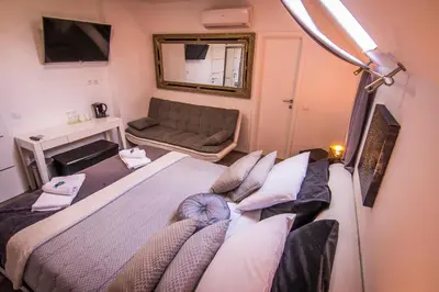 a bedroom with a large bed and a couch at Vila Lemic Postojna in Postojna