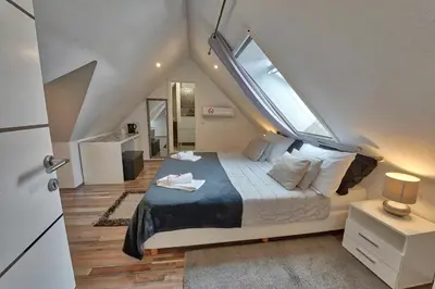 a bedroom with a large bed with a large window at Vila Lemic Postojna in Postojna