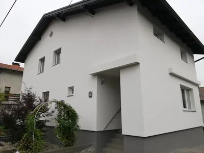 a white house with a black roof at ApartmentMR in Maribor