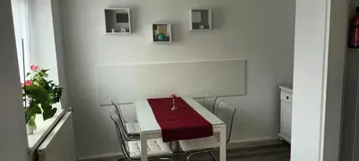 a white table and chairs with a red cloth on it at ApartmentMR in Maribor