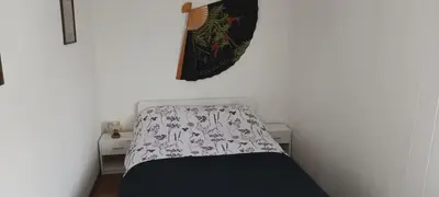 a small bedroom with a bed with a blanket on it at ApartmentMR in Maribor