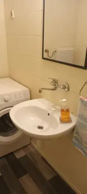 a bathroom with a sink and a washing machine at ApartmentMR in Maribor