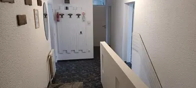 a hallway with a white door and a refrigerator at ApartmentMR in Maribor
