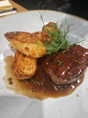 a plate of food with meat and bread with sauce at Hotel Bela Krajina in Metlika