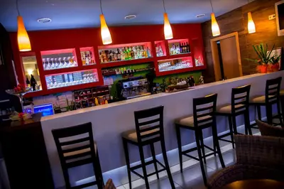 a bar with black stools in a restaurant at Hotel Bela Krajina in Metlika