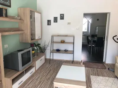 a living room with a television and a dining room at Apartma Mahnič in Postojna