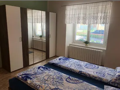 a bedroom with two beds and a large window at Apartma Mahnič in Postojna