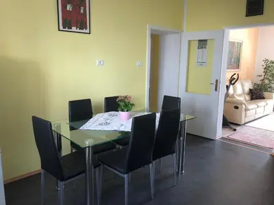 a dining room with a glass table and black chairs at Apartma Mahnič in Postojna