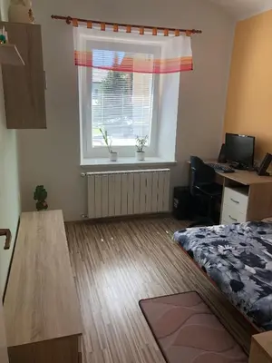 a bedroom with a bed and a window with a desk at Apartma Mahnič in Postojna