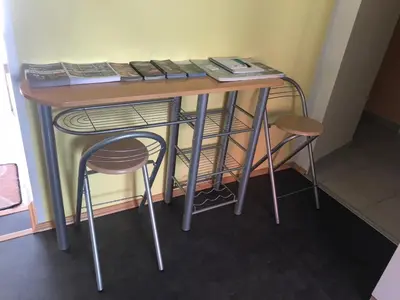 a table with books on top of it with a stool at Apartma Mahnič in Postojna