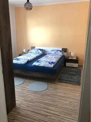 a bedroom with a bed with blue sheets on it at Apartma Mahnič in Postojna