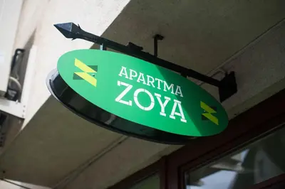 a green sign that readsarma zoya hanging from a building at Apartment Zoya in Kranjska Gora