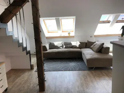 a living room with a couch and some windows at Apartma Linhartov trg in Radovljica